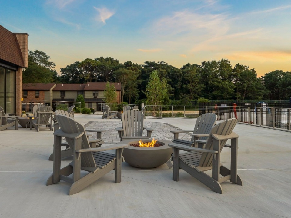 Adirondack chairs around a fire pit at dusk